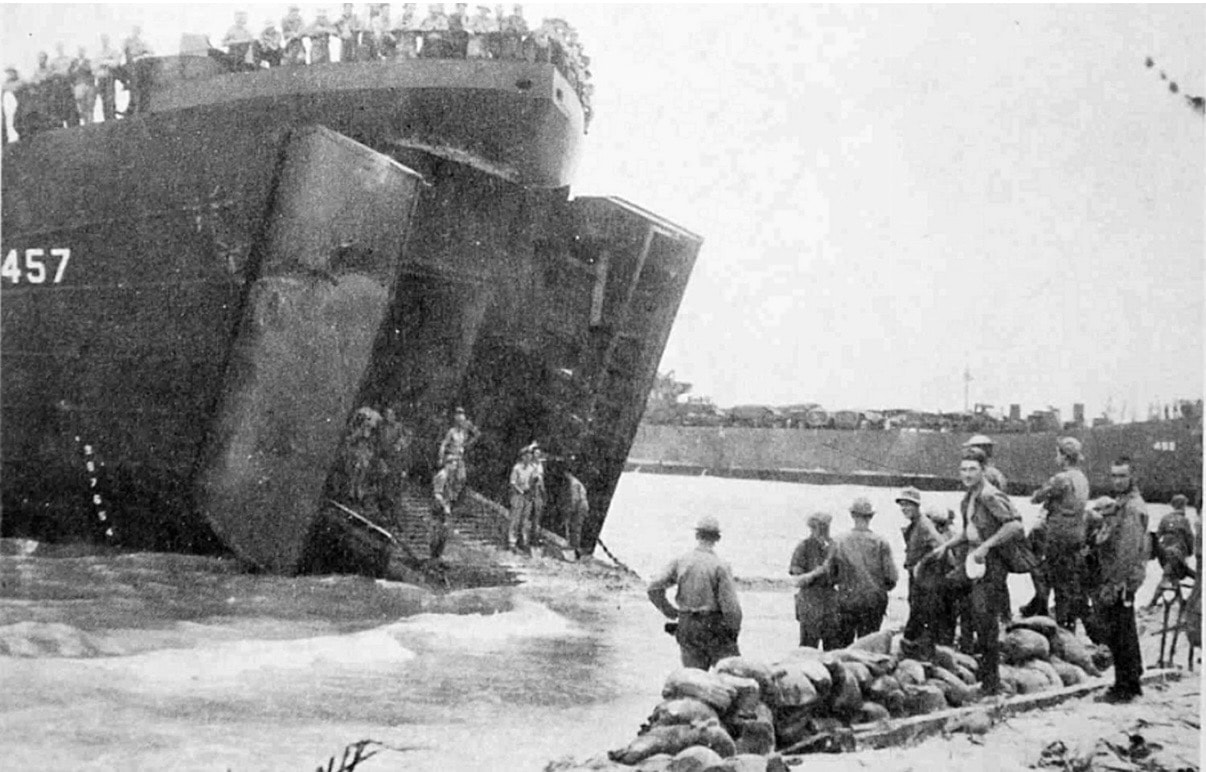 USS LST-457 — troops on beach with bow doors open, hull number 457 visible